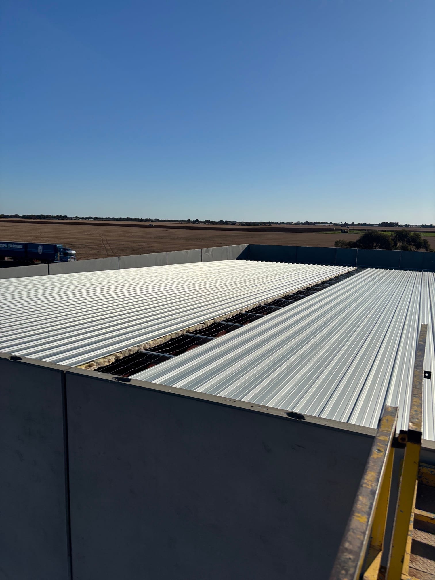 Long pristine corrugated Colorbond run on a warehouse roof in Direk, Adelaide by Pro Roof and Gutter