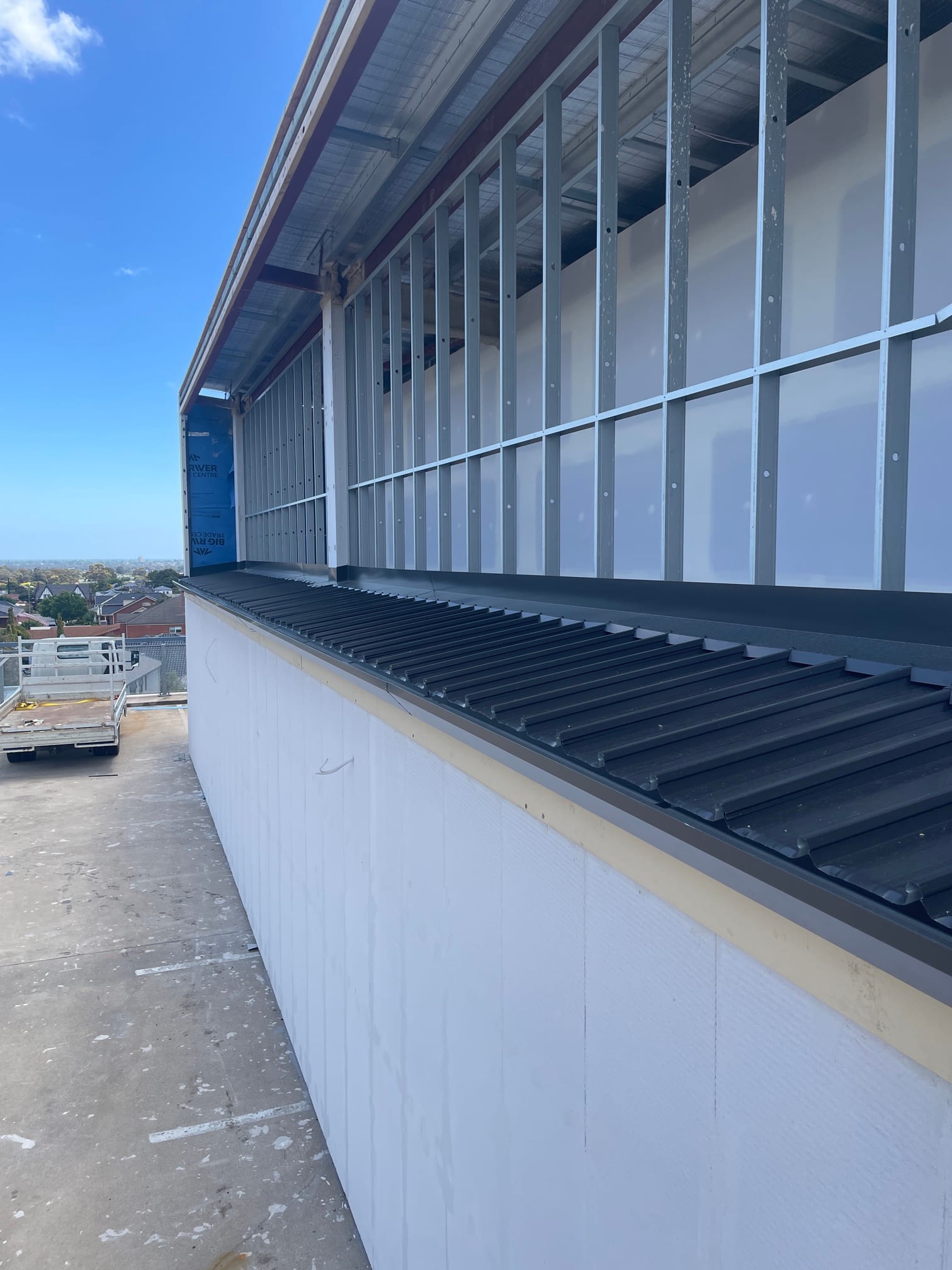 New Colorbond Kliplok roof with custom parapet capping and box gutter on a commercial building in Newton, Adelaide
